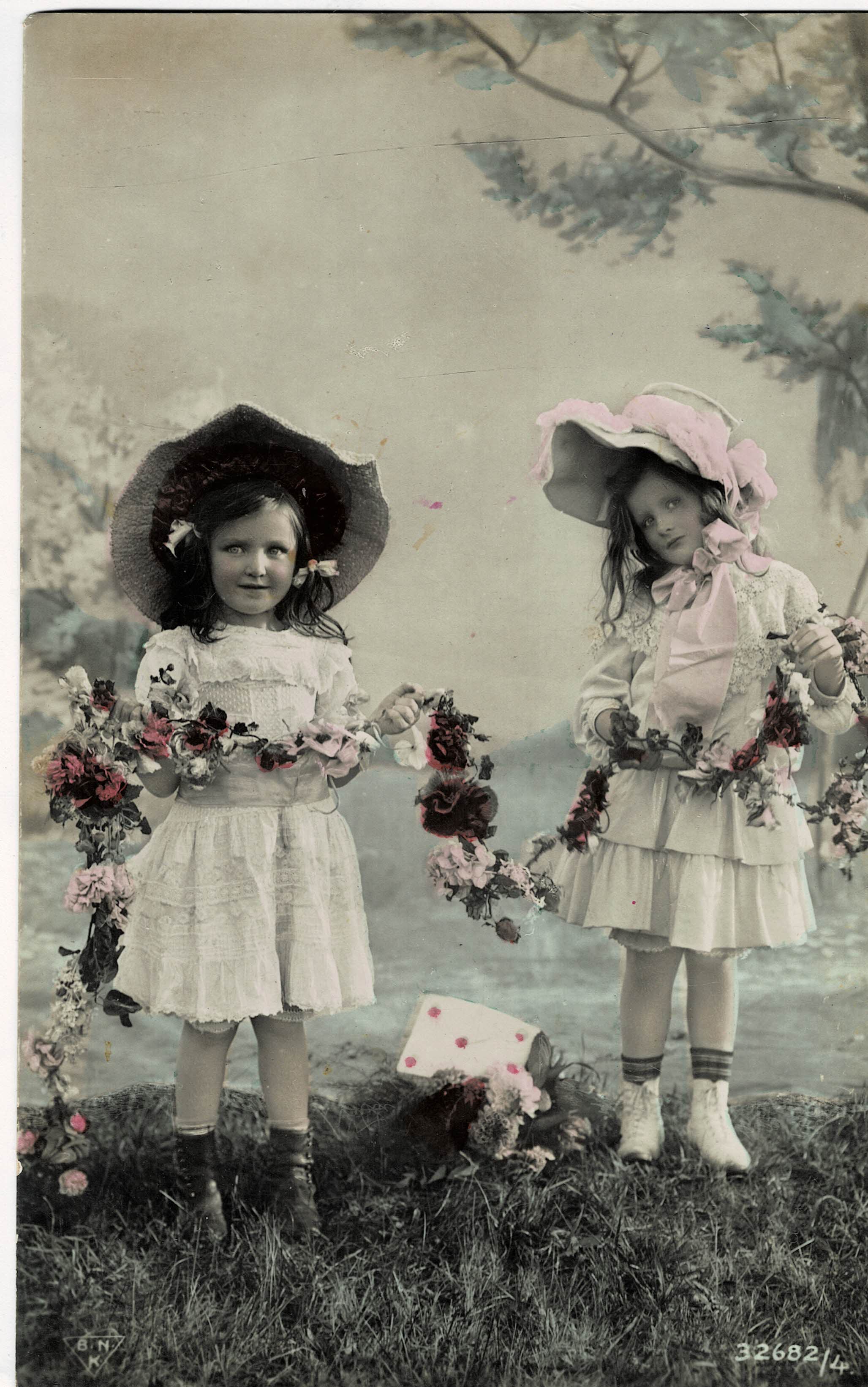 POSTAL NIÑAS EN JARDÍN CON FLORES.
