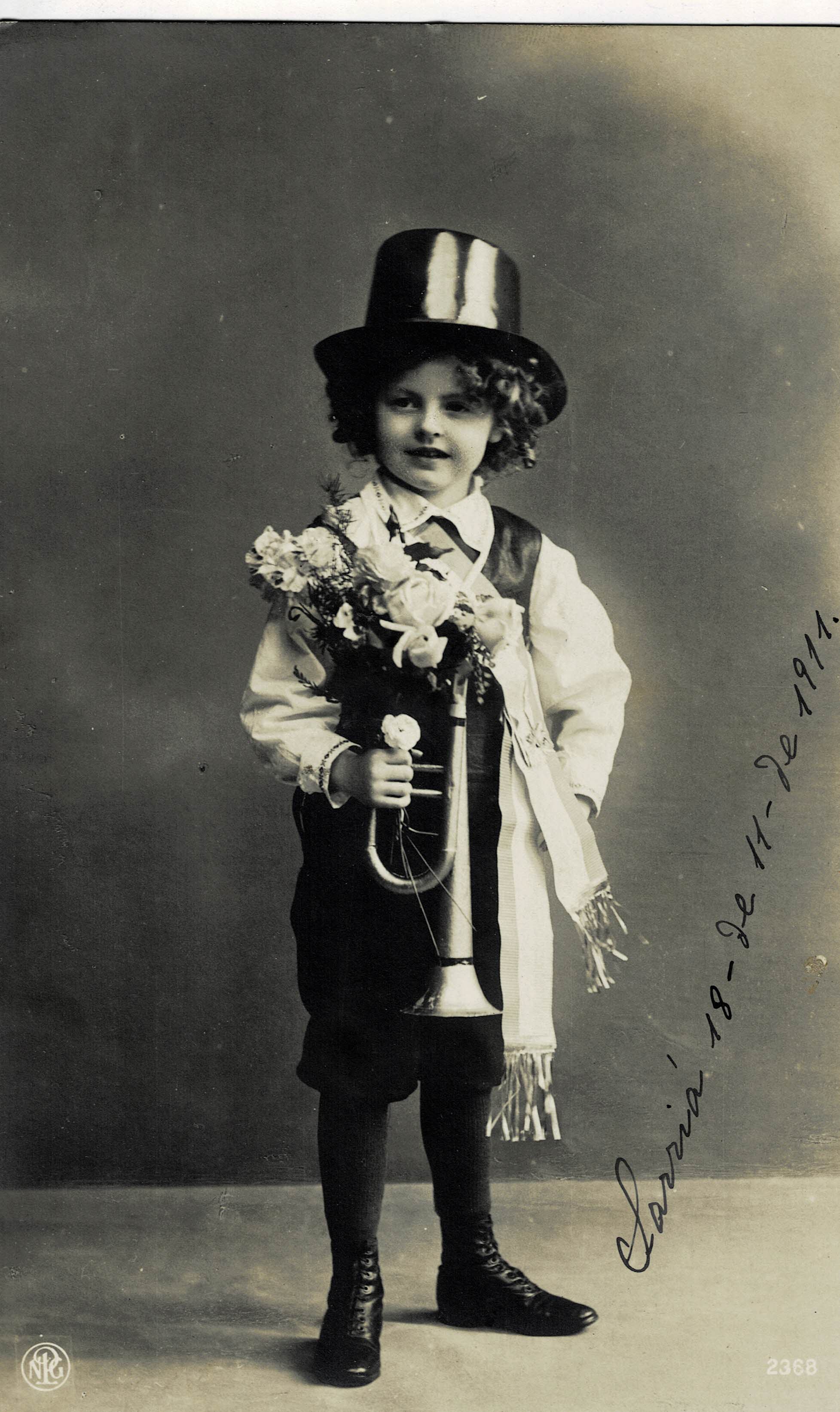 POSTAL NIÑO CON TROMPETA Y FLORES.