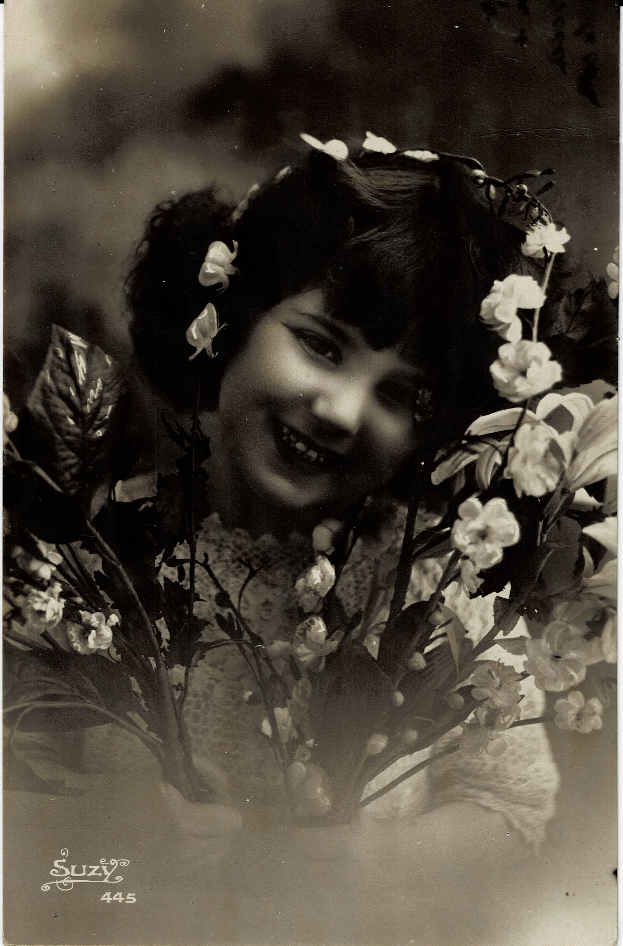 POSTAL NIÑA SONRIENDO CON FLORES.
