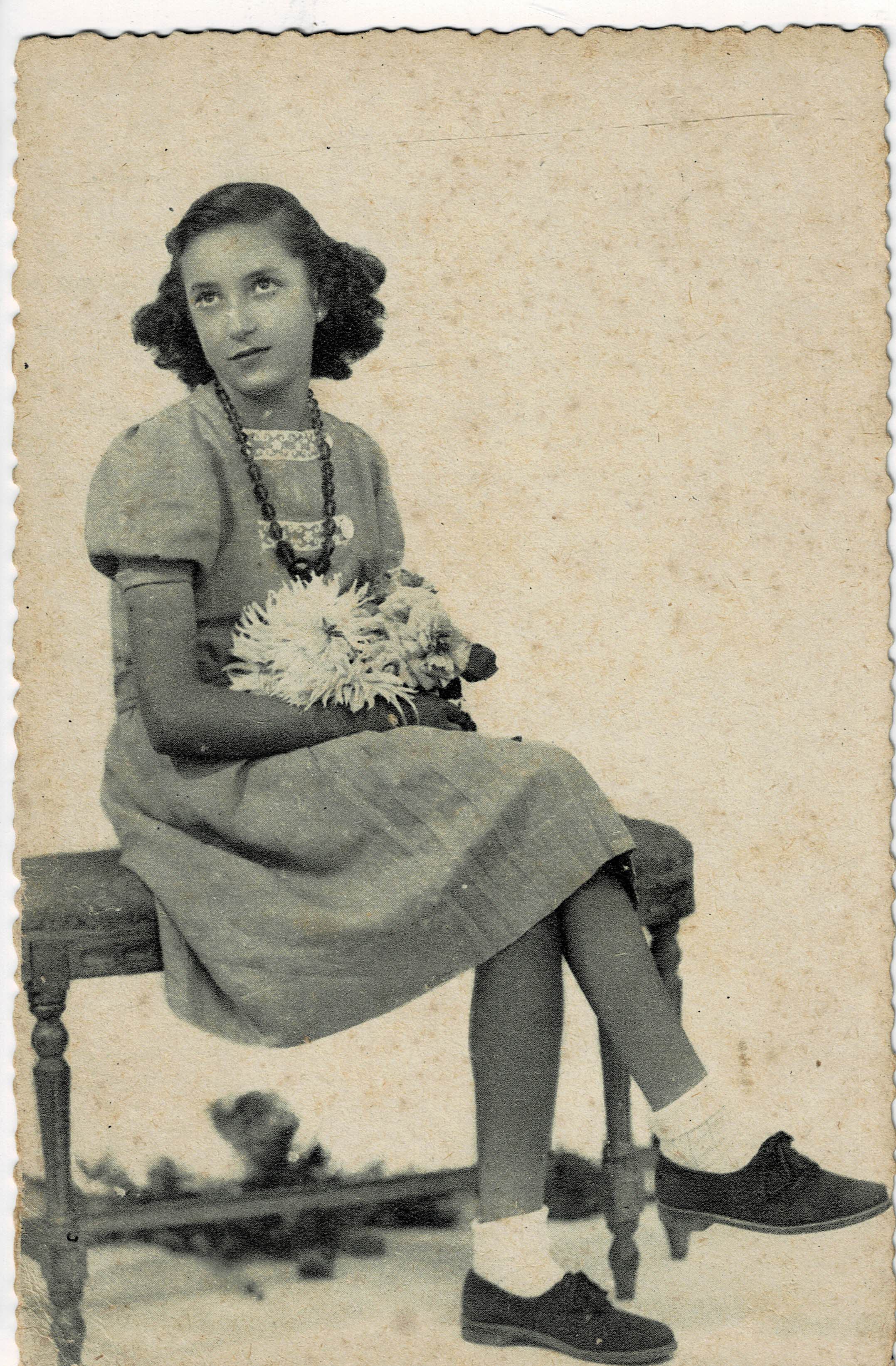 POSTAL NIÑA SENTADA CON FLORES.